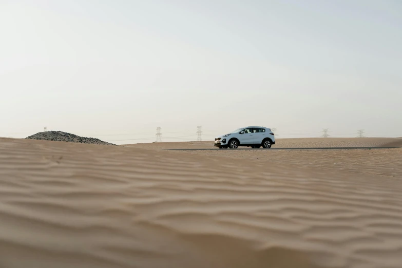 a car that is sitting in the sand, pexels contest winner, hurufiyya, in the desert beside the gulf, slightly minimal, hd footage, gravels around