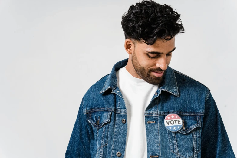 a man in a white t - shirt and a denim jacket, trending on pexels, stickers, politics, background image, riyahd cassiem