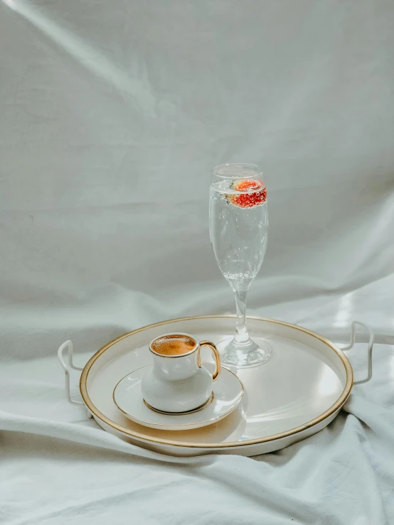 a cup of coffee sitting on top of a tray, a still life, pexels contest winner, minimalism, champagne, low quality photo, food photo, vintage photo