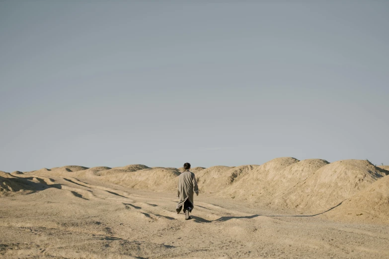 a man walking in the middle of a desert, inspired by Zhang Kechun, unsplash, les nabis, ai weiwei and gregory crewdson, knight of cups, ignant, movie still of a tired