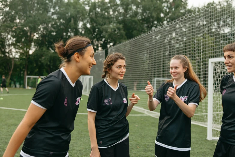 a group of young women standing on top of a soccer field, by Attila Meszlenyi, pexels contest winner, calmly conversing 8k, featuring pink brains, smiling slightly, athletic footage