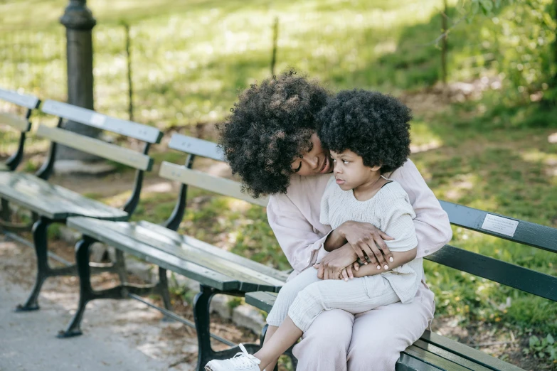 a woman and a child are sitting on a bench, pexels, with afro, embracing, instagram post, 1505