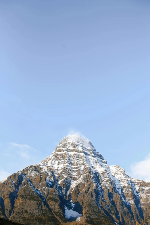 a group of people riding skis on top of a snow covered mountain, pointy conical hat, banff national park, minimalist photo, towering above a small person