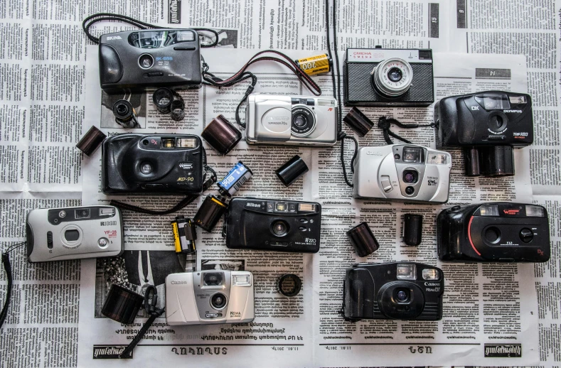 a bunch of cameras sitting on top of a newspaper, a picture, flatlay, '9 0 s, medium format, urban exploration