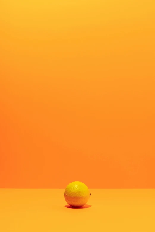 a lemon sitting on top of a table, inspired by Mike Winkelmann, pexels contest winner, postminimalism, orange gradient, demna gvasalia, desert, tennis ball