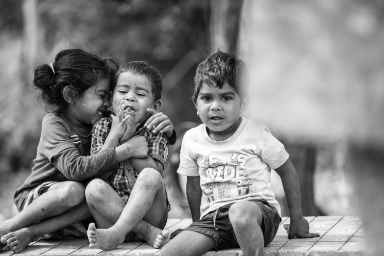 a couple of kids sitting next to each other, a black and white photo, by Joze Ciuha, pexels contest winner, sweet hugs, trio, on a village, face focus!