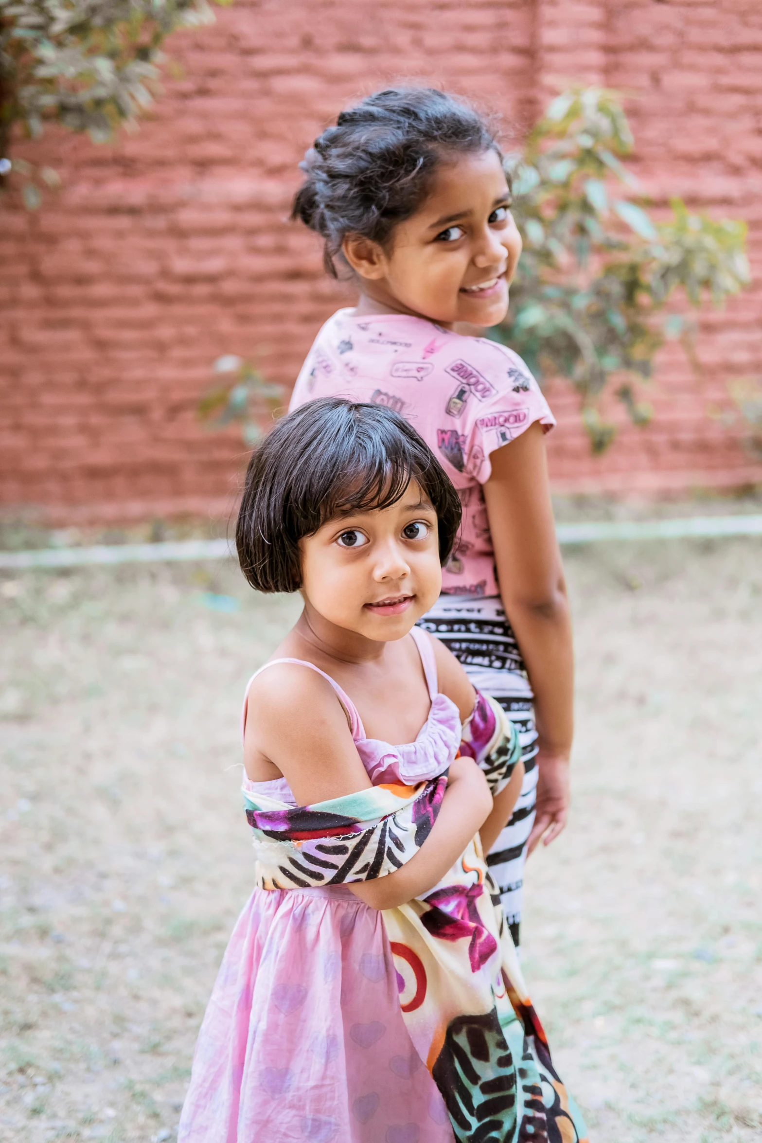 a couple of young girls standing next to each other, vastayan, loosely cropped, in the garden, kids playing