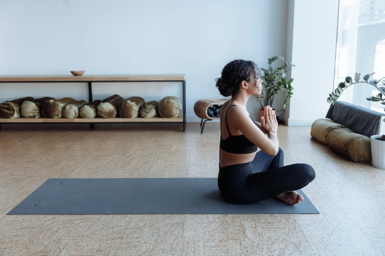 a woman sitting on a yoga mat in a room, unsplash, manuka, ouchh and and innate studio, background image