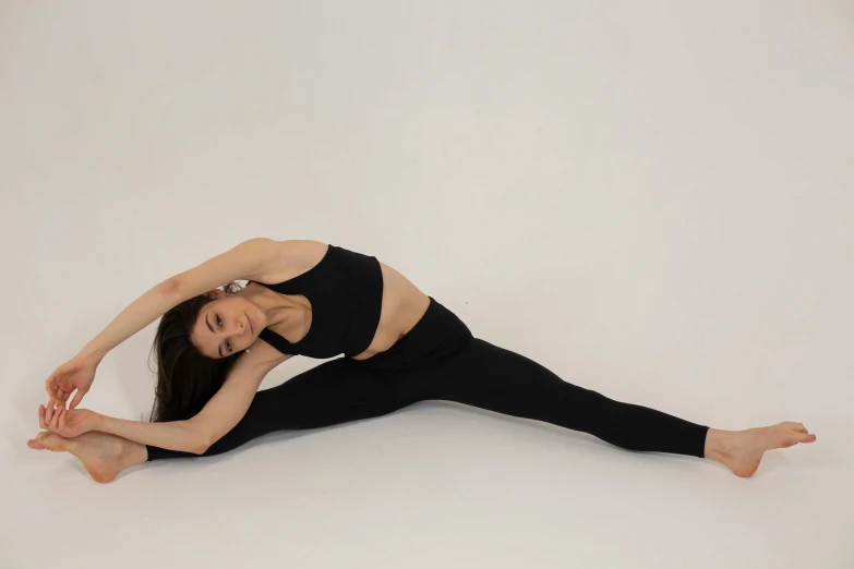 a woman doing a yoga pose on a white background, pexels contest winner, arabesque, black spandex, modeled, mai anh tran, 2 4 year old female model