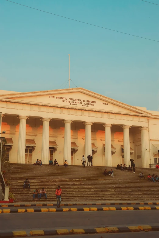 a large white building sitting on the side of a road, a statue, bengal school of art, sitting on a grand staircase, south jakarta, promo image, mini amphitheatre