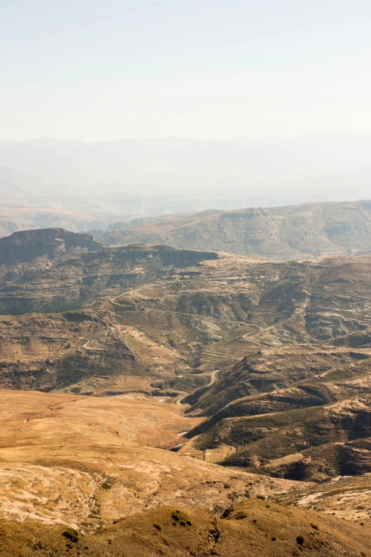 a view of a valley from the top of a mountain, inspired by Afewerk Tekle, mesa plateau, intense smoldering