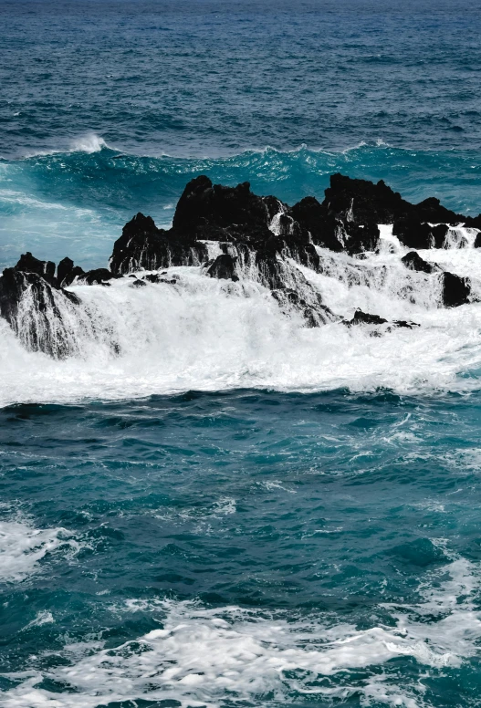 a man riding a surfboard on top of a wave in the ocean, jagged rocks, black and cyan color scheme, slide show, scattered islands