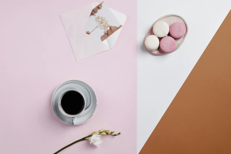 a cup of coffee and macaroons on a pink and orange background, inspired by André François, postminimalism, papers on table, detailed product image, white and pink, full product shot