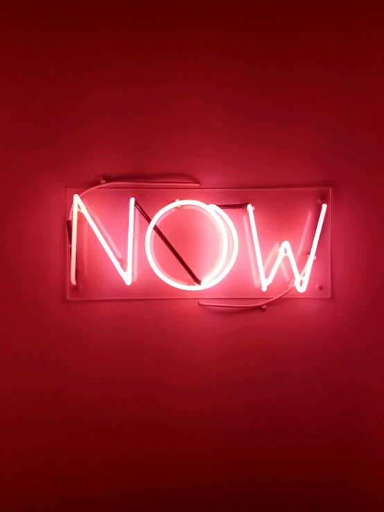 a neon sign that says now on a red wall, an album cover, trending on unsplash, happening, 💋 💄 👠 👗, showstudio, inner glow, no more