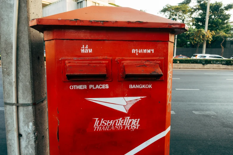 a red mail box sitting on the side of a road, an album cover, trending on unsplash, bangkok townsquare, rubber stamp, twice, alessio albi