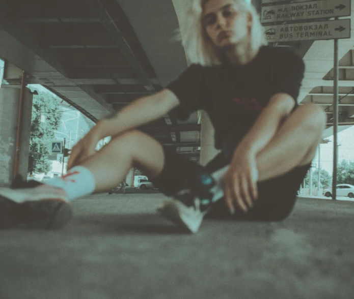 a person sitting on the ground with a skateboard, inspired by Elsa Bleda, unsplash, realism, wearing black tshirt, white haired, low quality photo, lomography photo