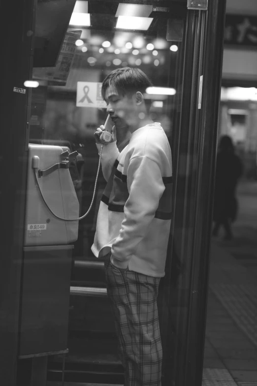 a black and white photo of a man talking on a phone, a black and white photo, inspired by Oskar Lüthy, japanese streetwear, ( ( ( buses, kiko mizuhara, scanned