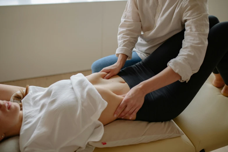 a woman getting a back massage in a room, unsplash, manly, poor quality, murata range, injured