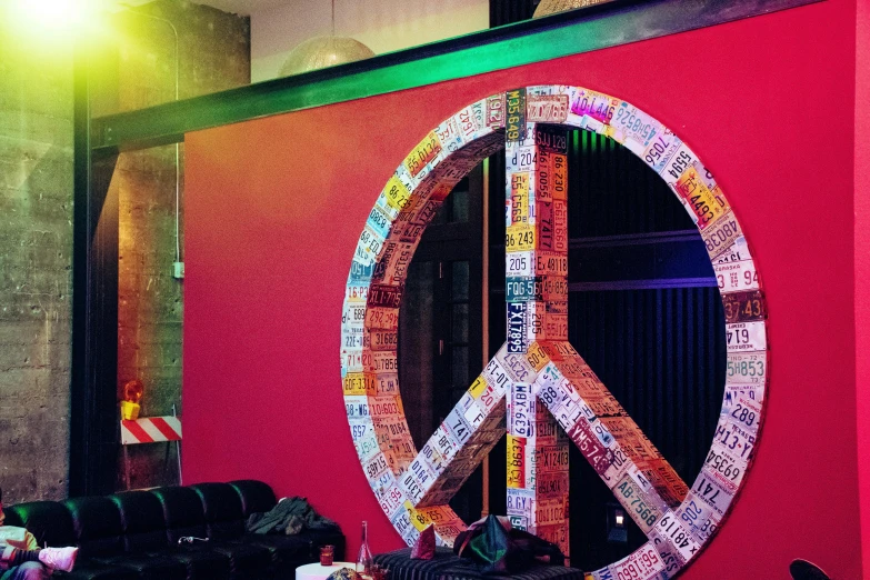 a red wall with a peace sign on it, inside a bar, multicoloured, profile image, decorations