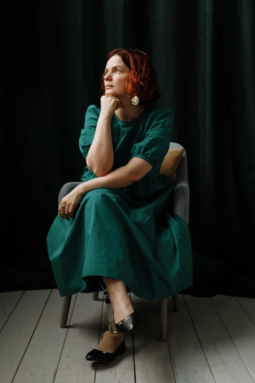 a woman in a green dress sitting on a chair, kirsi salonen, woman with red hair, androgynous person, taken in 2 0 2 0