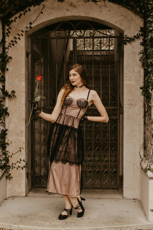 a woman standing in front of a door holding a rose, inspired by George barbier, unsplash, renaissance, brown corset, outdoor photo, gothic dress, balcony