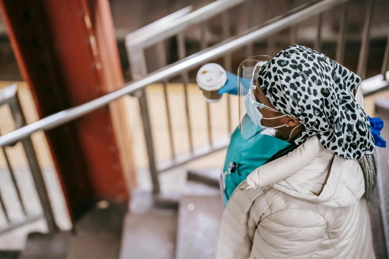 a woman in a white coat and a leopard print scarf, pexels contest winner, happening, healthcare worker, coming down the stairs, aida muluneh, oxygen mask