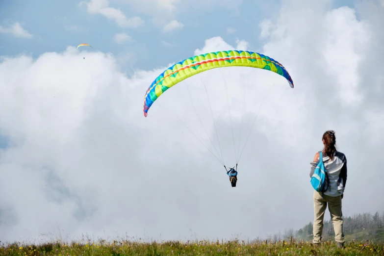 a person that is flying a kite in the sky, on the mountain, chartreuse and orange and cyan, softair center landscape, traverse