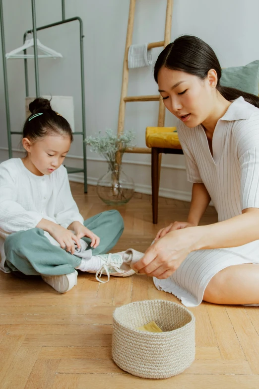 a woman sitting on the floor next to a little girl, wearing white sneakers, weaving, korean, cleanest image