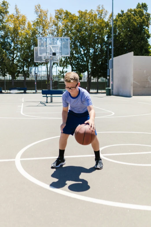 a little boy standing on top of a basketball court holding a ball, wearing shorts, intense line work, sport glasses, carson ellis