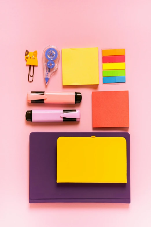 a variety of office supplies laid out on a pink surface, trending on pexels, color field, yellow and purple color scheme, school class, rectangle, uplit