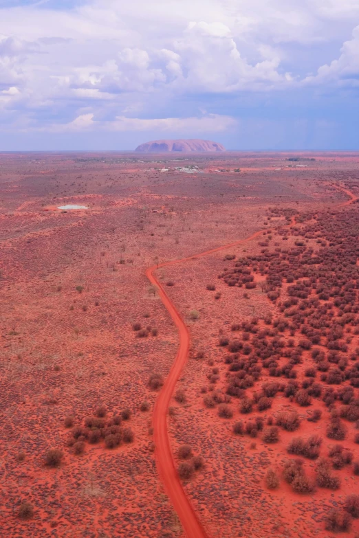 an aerial view of a dirt road in the outback, an album cover, land art, uluru, 4 k ”, may)