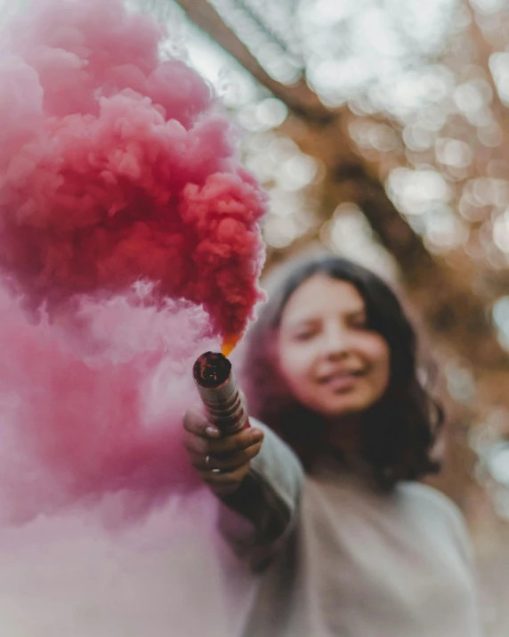 a woman holding a pink smoke bomb in her hand, happy colours, trans rights, instagram post, happy kid