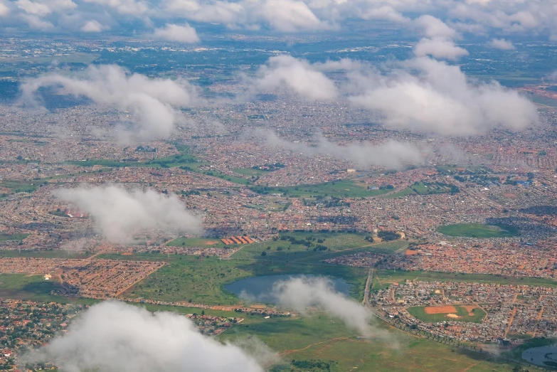 a view of a city from an airplane, inspired by Joze Ciuha, pexels contest winner, renaissance, landscape of africa, clouds and fields in background, suburbia, subsiding floodwaters