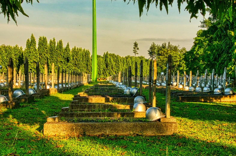 a bunch of metal balls sitting on top of a lush green field, cemetery, south jakarta, lamp posts, in a row