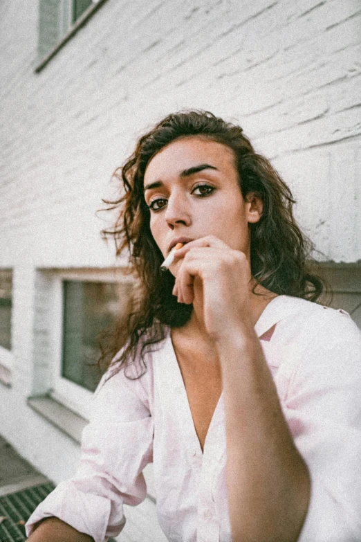 a woman sitting at a table with a laptop, a picture, trending on unsplash, antipodeans, portrait androgynous girl, robert sheehan, in front of a garage, an all white human