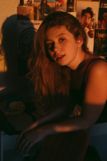 a woman sitting in front of a laptop computer, an album cover, inspired by Nan Goldin, trending on pexels, renaissance, long glowing hair, portrait casting long shadows, in a bedroom, grace moretz