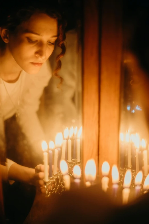 a woman blowing out candles on a cake, inspired by Elsa Bleda, renaissance, sacred perfect lighting, in a room full of candles, holiday season, on a candle holder