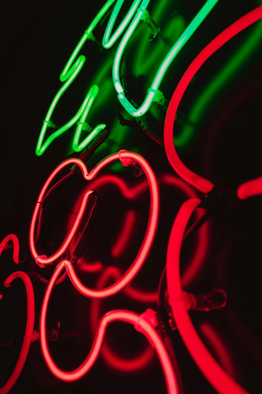 a neon sign hanging from the side of a building, inspired by Bruce Munro, pexels, kinetic art, apples, red green, medium closeup, made of neon light