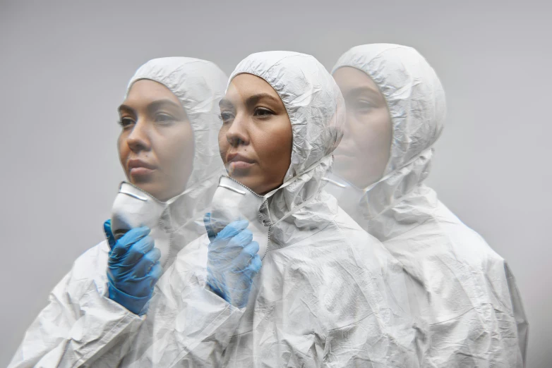 a couple of women standing next to each other, an album cover, by Adam Marczyński, pexels contest winner, hyperrealism, hazmat suits, three women, diverse medical cybersuits, wearing translucent veils