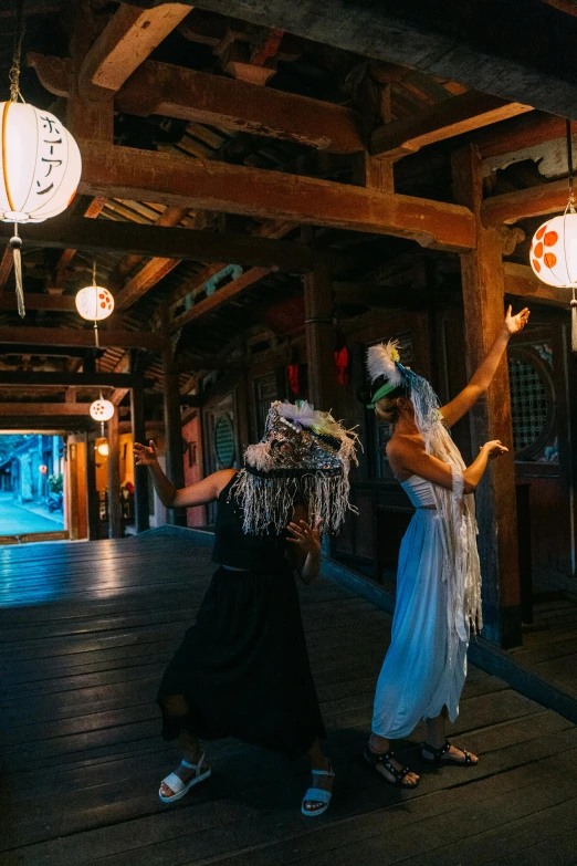 a couple of women standing on top of a wooden floor, inspired by Kanō Shōsenin, evil spirits roam with lanterns, girl in white dress dancing, slide show, elaborately costumed