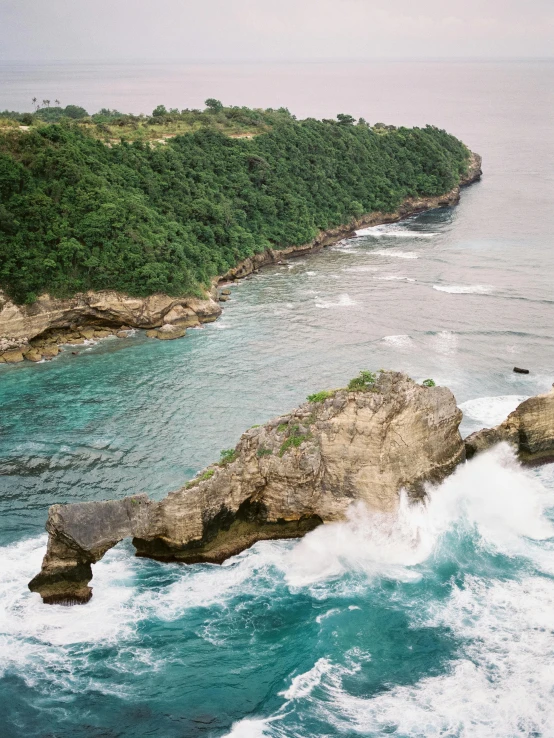 a large body of water next to a lush green hillside, a picture, pexels contest winner, sumatraism, waves crashing at rocks, limestone, conde nast traveler photo, slide show
