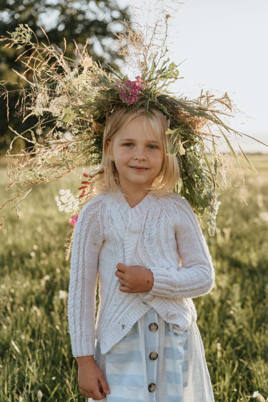 a little girl standing in a field with a flower crown on her head, inspired by Elsa Beskow, pexels contest winner, wearing a cardigan, ready to model, roots and hay coat, white