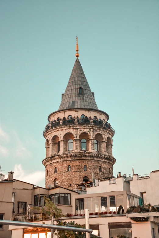 a tall tower sitting in the middle of a city, inspired by Altoon Sultan, trending on pexels, art nouveau, rounded roof, tall terrace, byzantine, round-cropped