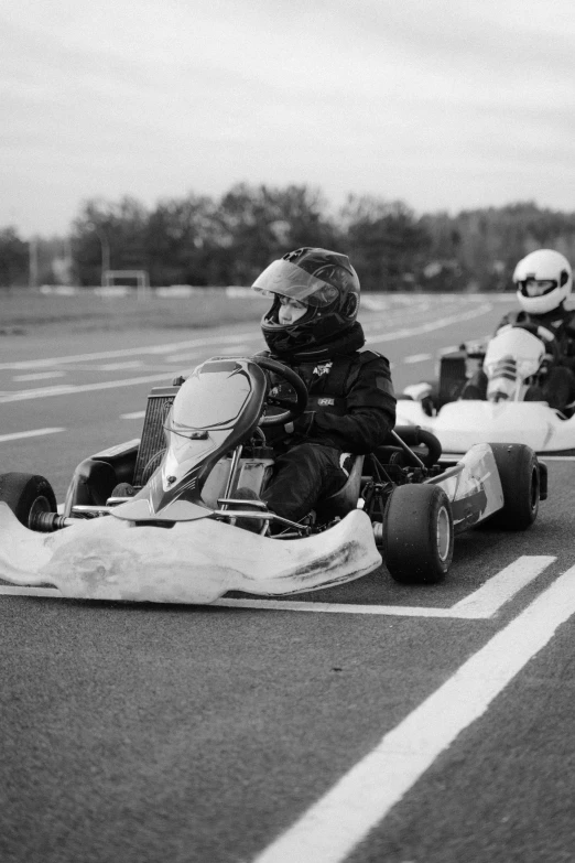 a group of people riding go karts down a road, a black and white photo, by Cornelisz Hendriksz Vroom, medium format. soft light, uploaded, sport, cute photo