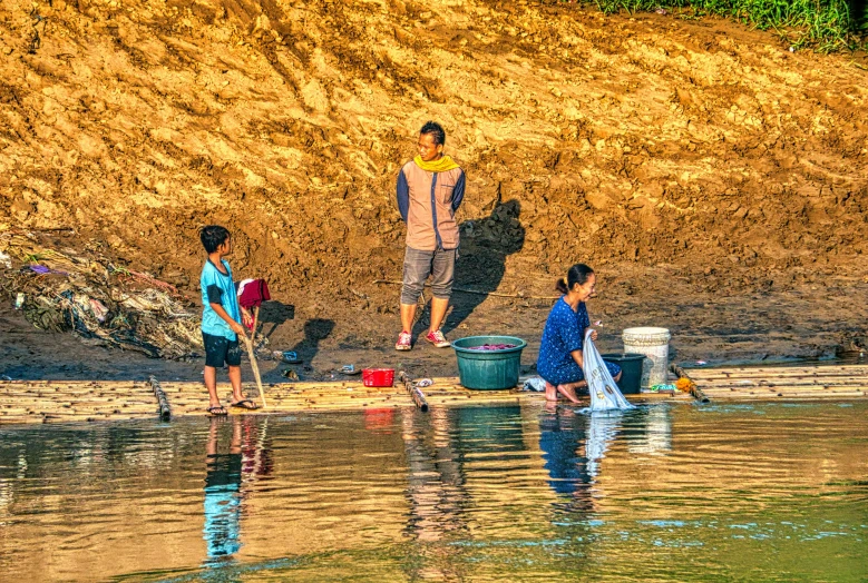 a group of people standing next to a body of water, a photo, by Bruce Gilden, process art, working hard, full morning sun, asian man, families playing