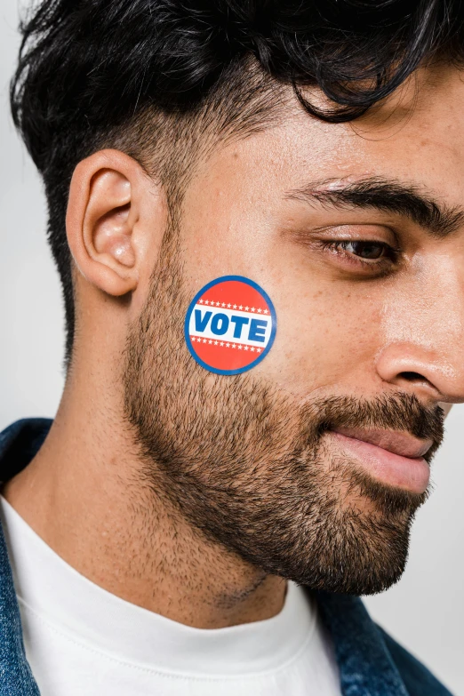 a man with a vote sticker on his face, a colorized photo, inspired by Bernie D’Andrea, trending on pexels, masculine jawline, attractive young man, arab man light beard, instagram story