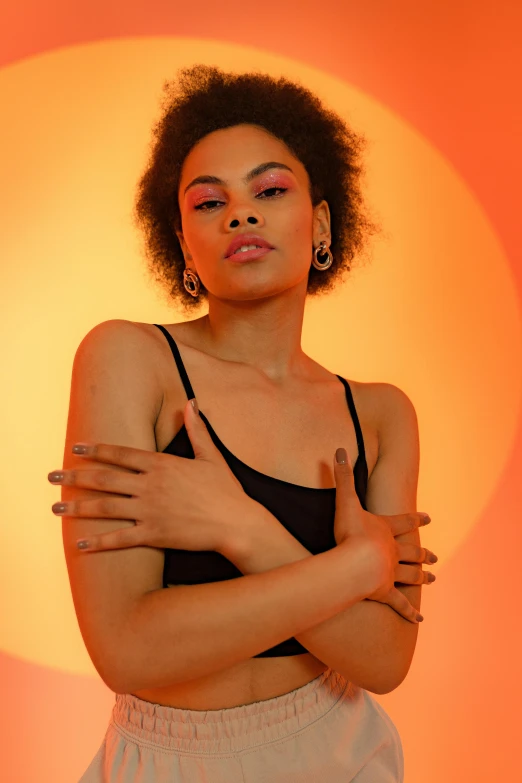 a woman in a black top and white shorts, trending on pexels, visual art, orange neon backlighting, doing a sassy pose, mixed-race woman, promotional image