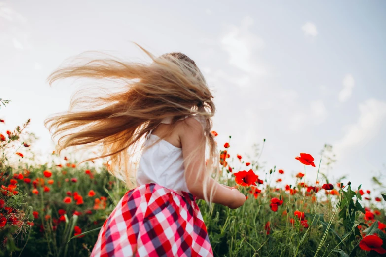 a little girl standing in a field of red flowers, pexels contest winner, her hair blowing in the wind, long blond hair, windy floating hair!!, beauty girl