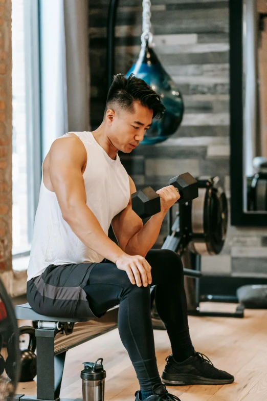 a man sitting on a bench in a gym, a colorized photo, pexels contest winner, asian human, lifting weights, cottagecore!! fitness body, hoang lap