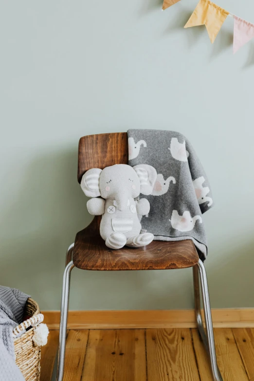 a wooden chair with a blanket on top of it, a picture, stuffed toy, a photo of an elephant, full product shot, medium-shot